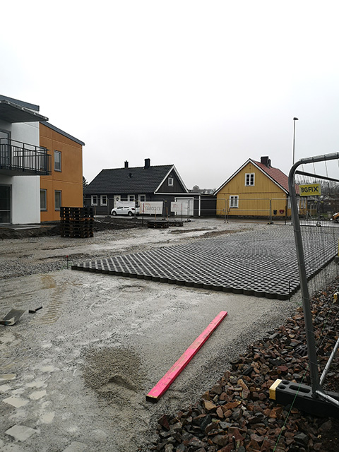 Yta framför hus får gräsarmering på packad grus.